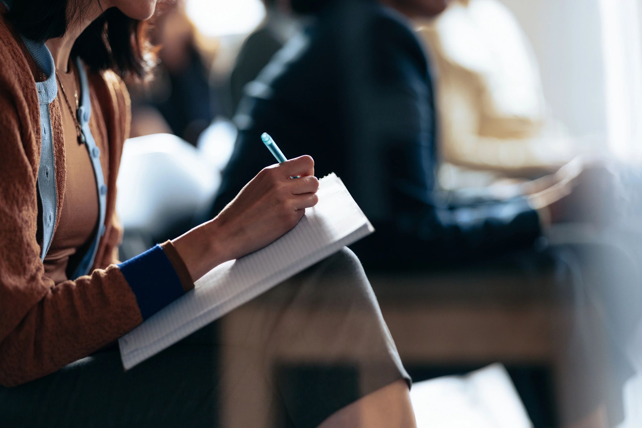 Person taking notes in a notebook during a learning session